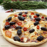 Pizza mit Peperoni, Schafskäse und schwarzen Oliven