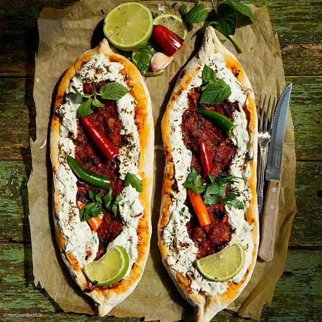 Pide, saftig und kross, mit Tomaten-Kreuzkümmelsauce, Knoblauch, Blattpetersilie, Peperoni