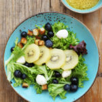 Sommersalat mit Zespri SunGold Kiwis, Mozzarella, Blaubeeren, Knoblauchcroûtons und einer Orangen-Kokos-Vinaigrette