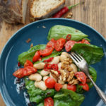 Spinatsalat mit weißen Riesenbohnen, Kirschtomaten, Walnüssen und einer Himbeermarmelade-Peperoni-Vinaigrette