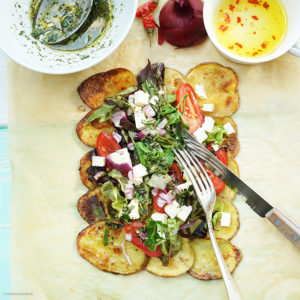 Mediterraner Salat mit Feta auf gerösteten Kartoffelscheiben mit einer Rosmarin-Estragon Vinaigrette