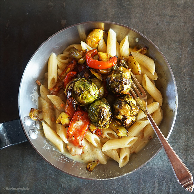 Im Ofen geschmorter spicy Rosenkohl, Paprika, Lauch und Zwiebeln auf Penne Rigate mit einer Erdnuss-Kokosmilch-Sauce