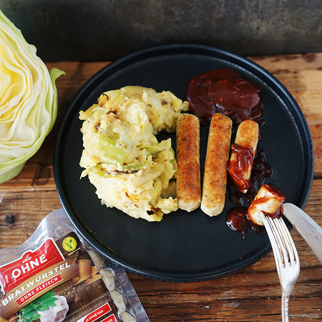 Kartoffelstampf mit geschmortem Spitzkohl und vegetarischen Bratwürstchen