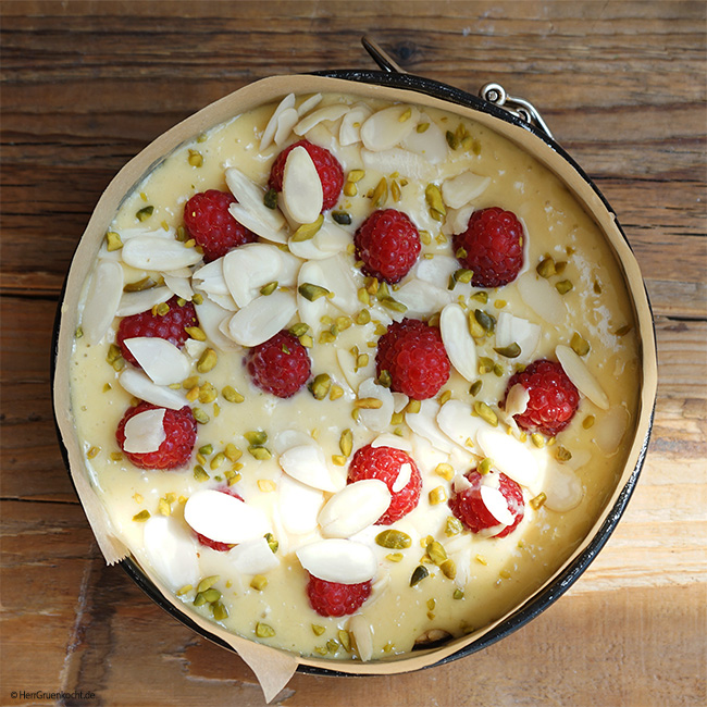 Joghurt-Himbeerkuchen mit Kokos, Mandelblättchen, gehackten Pistazien auf einem krossen Mürbeteigboden