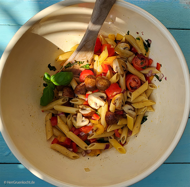 Veganer mediterraner Nudelsalat mit Paprika rot und gelb, Oliven, Tomaten und gebratenen Pilzen