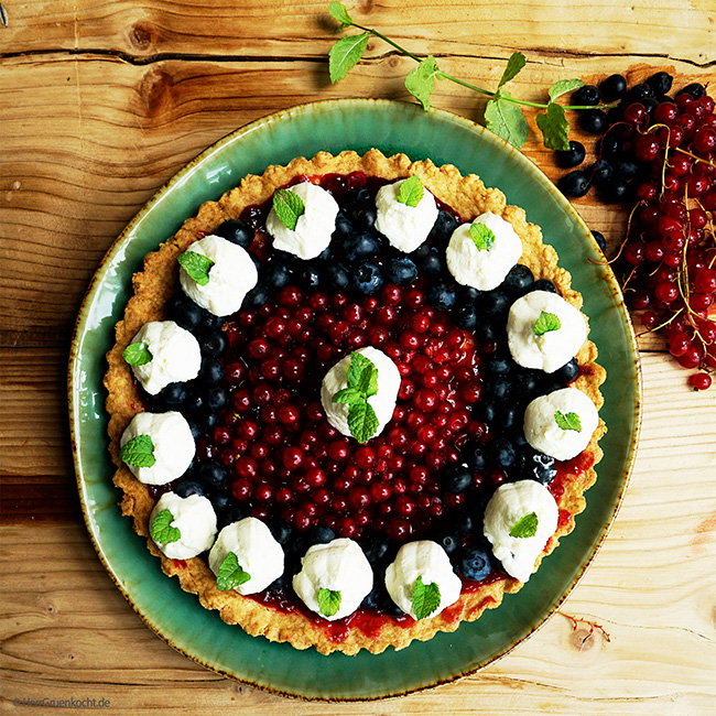 Beerentarte mit Mürbeteigboden, Johannisbeeren, Blaubeeren, Vanille-Mascarpone-Sahne und Minzblättern