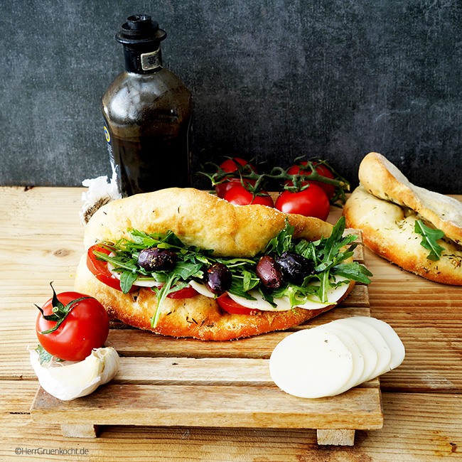 Pizza-Sandwich mit Knoblauch-Thymian-Öl, Tomaten, Rucola und No-Zarella-Scheiben