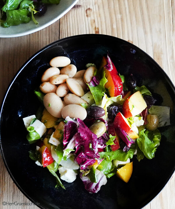 Sommersalat mit Pflücksalat, Nektarinen, Schafskäse, Oliven und weiße ...